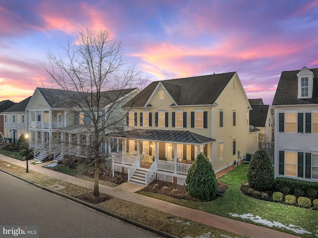 view of front of home featuring covered porch and a lawn