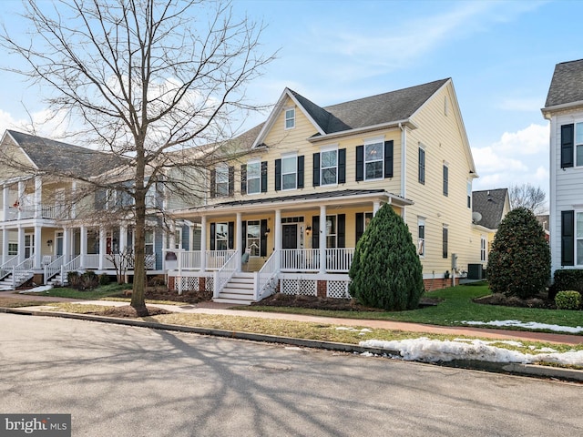 view of front facade with a front lawn, central air condition unit, and covered porch