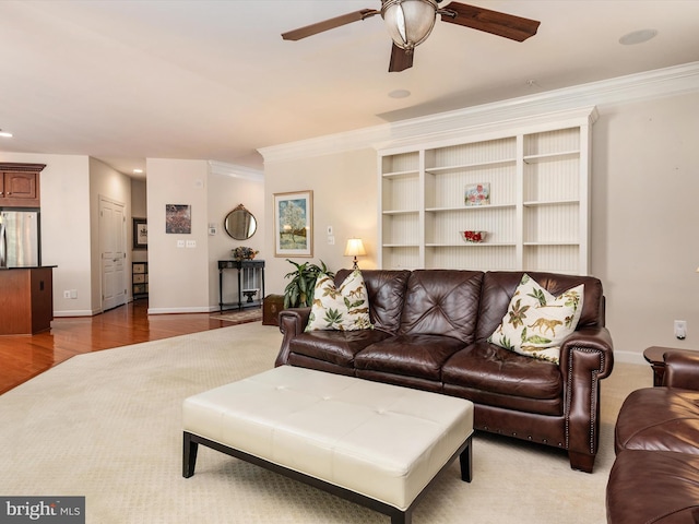 living room featuring crown molding, ceiling fan, and light hardwood / wood-style floors