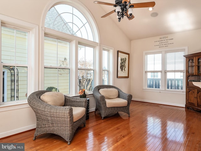 sitting room with wood-type flooring, high vaulted ceiling, and ceiling fan