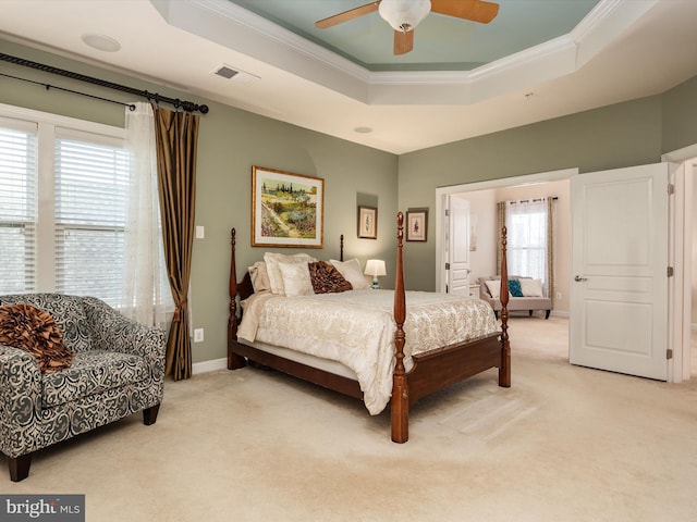 carpeted bedroom featuring crown molding, ceiling fan, and a tray ceiling