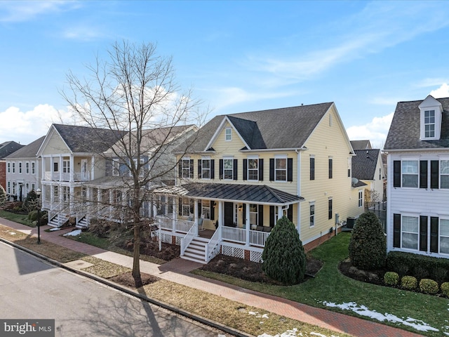 view of front facade featuring a porch, central AC unit, and a front lawn