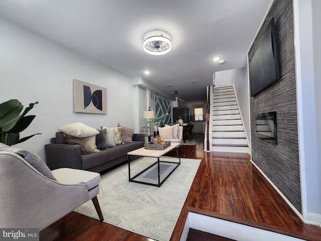 living room featuring wood-type flooring and a brick fireplace