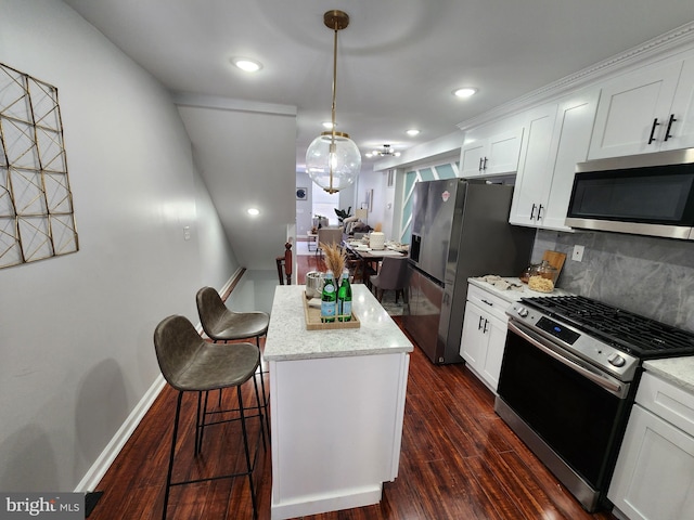 kitchen featuring light stone countertops, white cabinets, appliances with stainless steel finishes, and tasteful backsplash