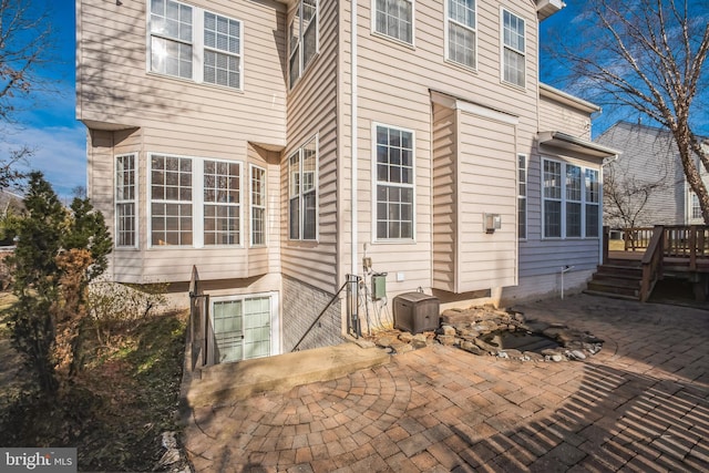 view of home's exterior with a deck and a patio