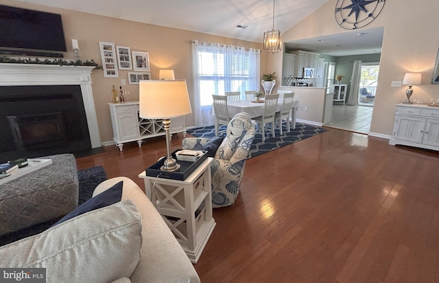 living room featuring plenty of natural light, dark hardwood / wood-style flooring, and lofted ceiling