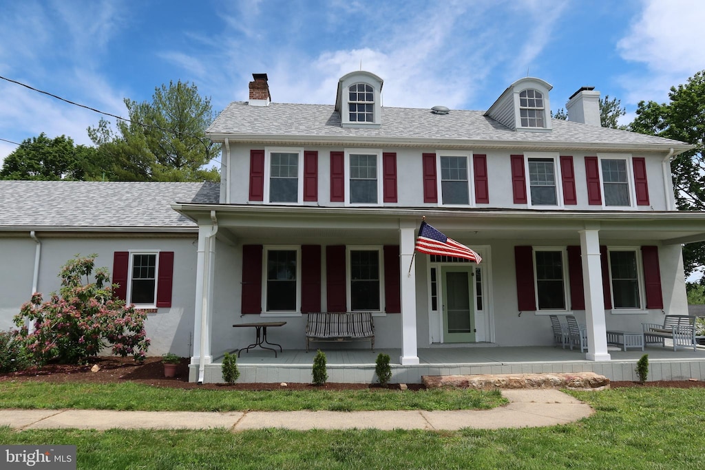 5961 Limestone Rd, Hockessin, DE 19707 - view of front facade with covered porch, a chimney, stucco siding, and a shingled roof