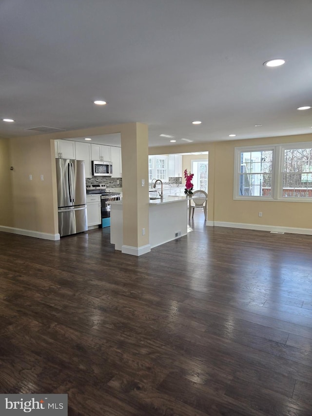 unfurnished living room with dark hardwood / wood-style floors and sink