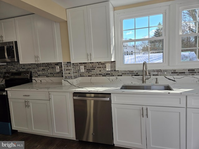 kitchen featuring stainless steel appliances, sink, white cabinets, and light stone counters