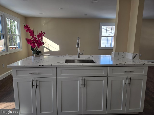 kitchen featuring white cabinetry, sink, and light stone counters