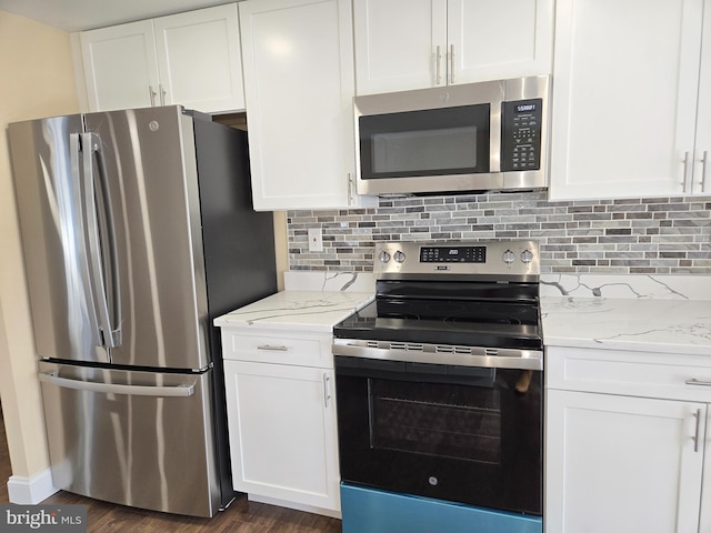 kitchen featuring white cabinetry, appliances with stainless steel finishes, light stone counters, and backsplash