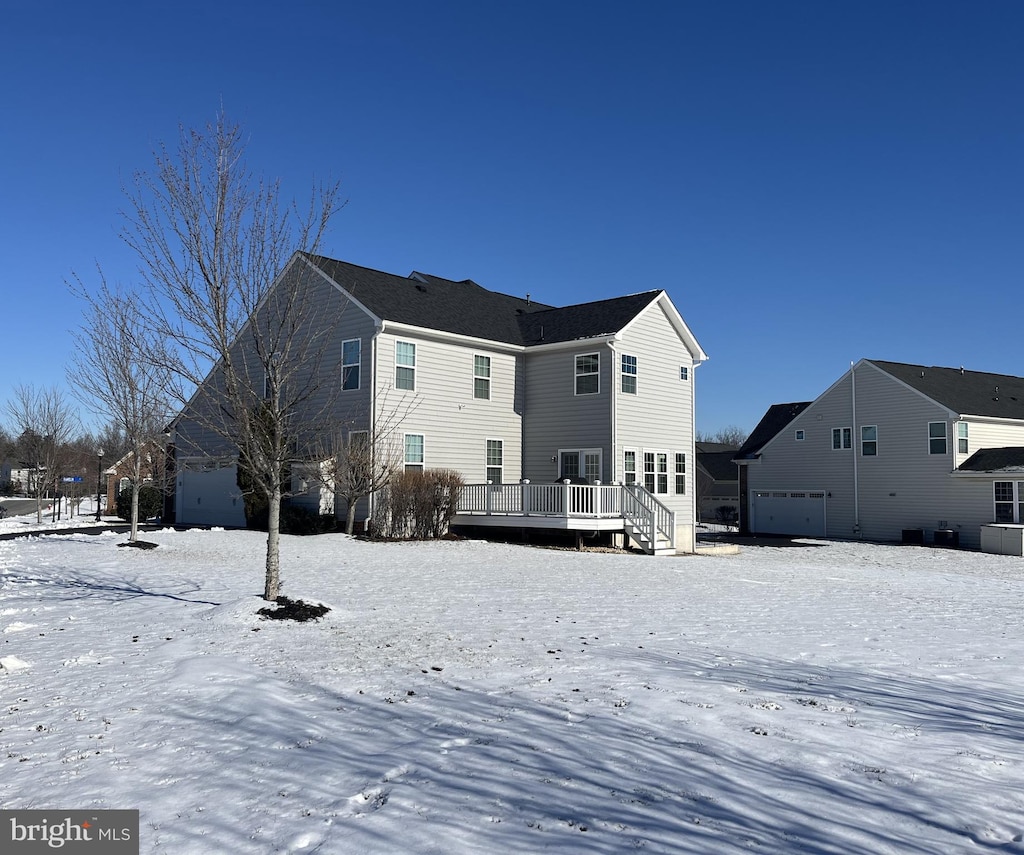 snow covered property featuring a wooden deck