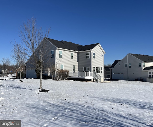 snow covered rear of property featuring a deck