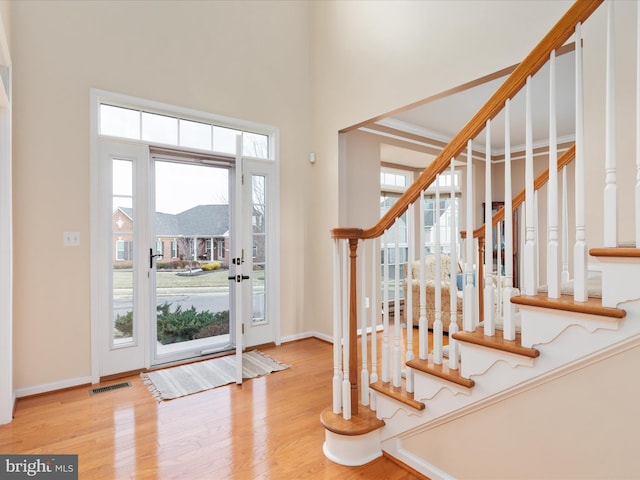 foyer featuring a towering ceiling and light hardwood / wood-style floors