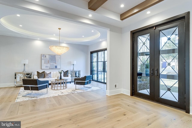 foyer with a raised ceiling, recessed lighting, french doors, and baseboards