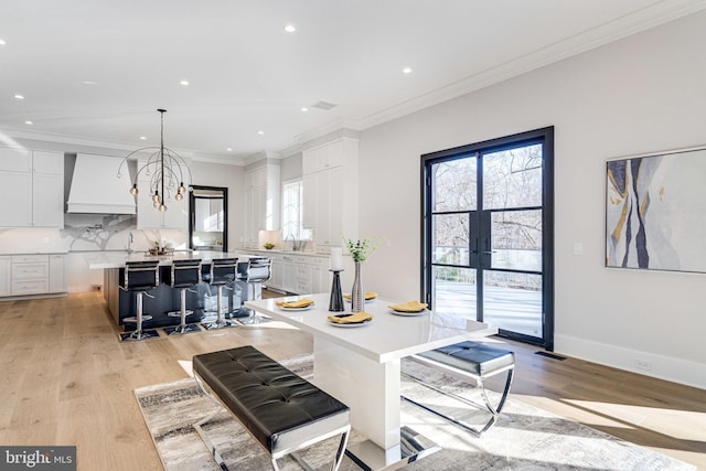 kitchen with a center island, a breakfast bar area, light countertops, custom range hood, and white cabinetry