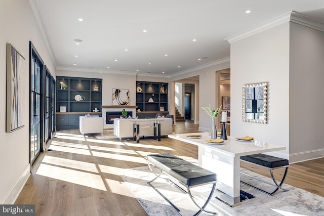 interior space with recessed lighting, stairway, a lit fireplace, light wood finished floors, and baseboards