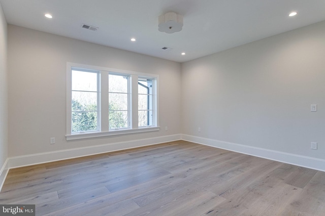 unfurnished room featuring light wood-type flooring, visible vents, baseboards, and recessed lighting