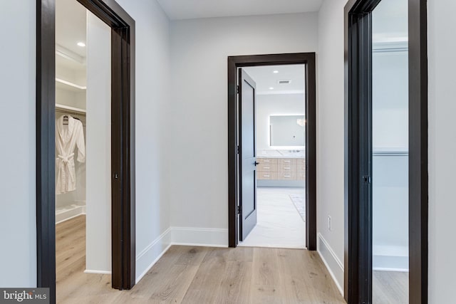 hallway with visible vents, light wood-style flooring, recessed lighting, and baseboards