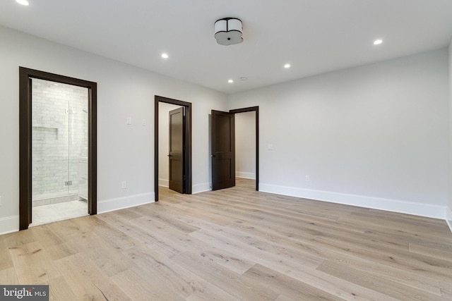 unfurnished bedroom with light wood-style flooring, recessed lighting, baseboards, and ensuite bathroom