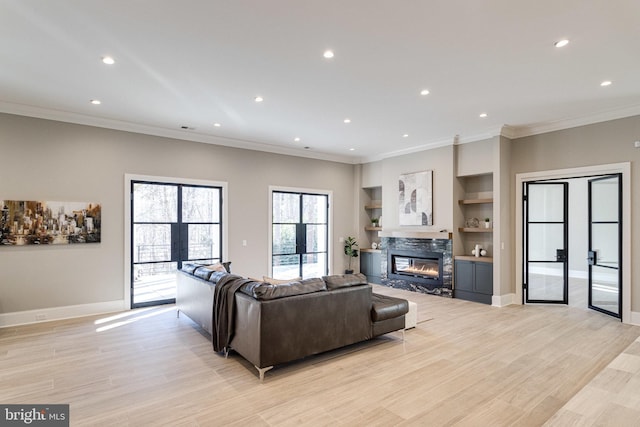 living area featuring light wood-type flooring, recessed lighting, french doors, a fireplace, and baseboards