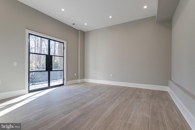 spare room featuring visible vents, recessed lighting, baseboards, and light wood-style floors