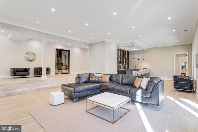 living room with recessed lighting, light wood-style floors, baseboards, and ornamental molding