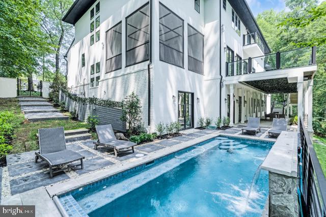 back of property featuring a balcony, a fenced in pool, a patio, and stucco siding