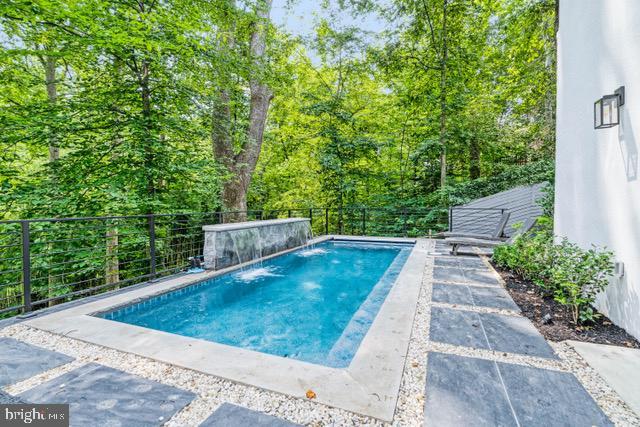 outdoor pool featuring a fenced backyard