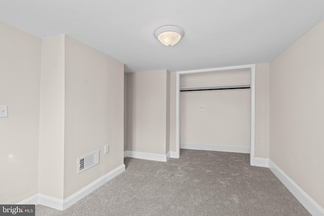 unfurnished bedroom featuring light carpet and a closet