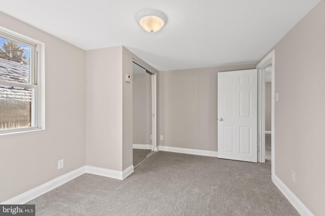 unfurnished bedroom featuring light carpet and a closet