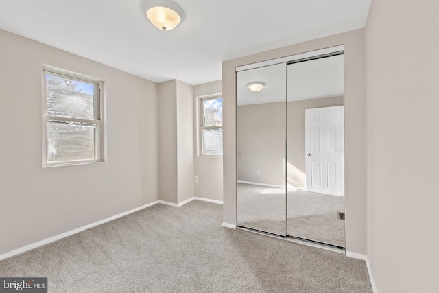 unfurnished bedroom featuring carpet flooring and a closet