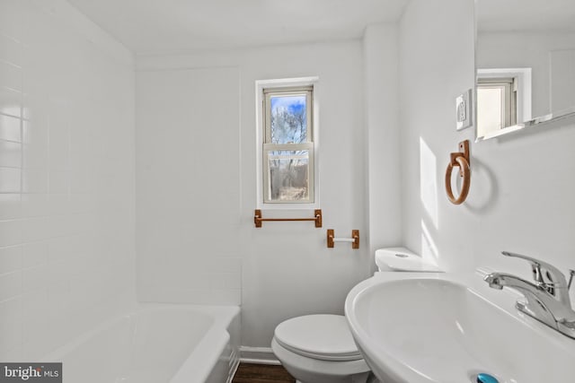 bathroom with plenty of natural light, toilet, and sink