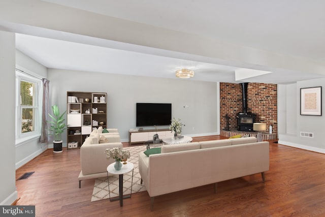 living room with hardwood / wood-style flooring and a wood stove