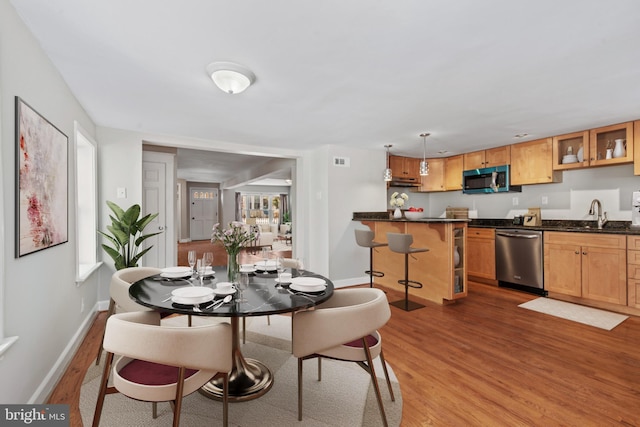 dining space featuring hardwood / wood-style flooring and sink