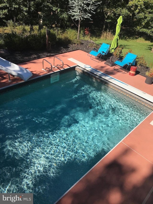 view of pool with a patio area and a water slide