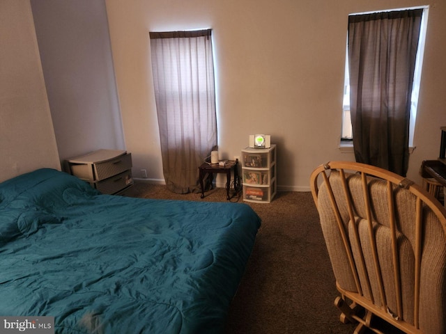 bedroom featuring multiple windows and dark colored carpet