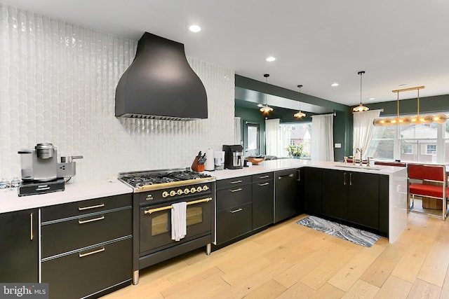 kitchen featuring premium range hood, sink, hanging light fixtures, double oven range, and kitchen peninsula