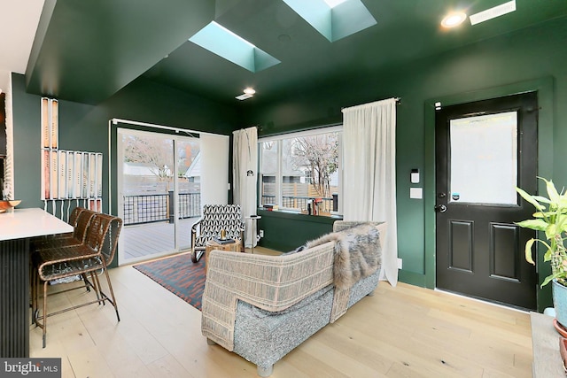 living room featuring wood-type flooring and a skylight