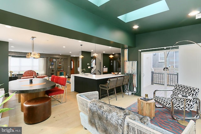 living room with light hardwood / wood-style flooring and a skylight