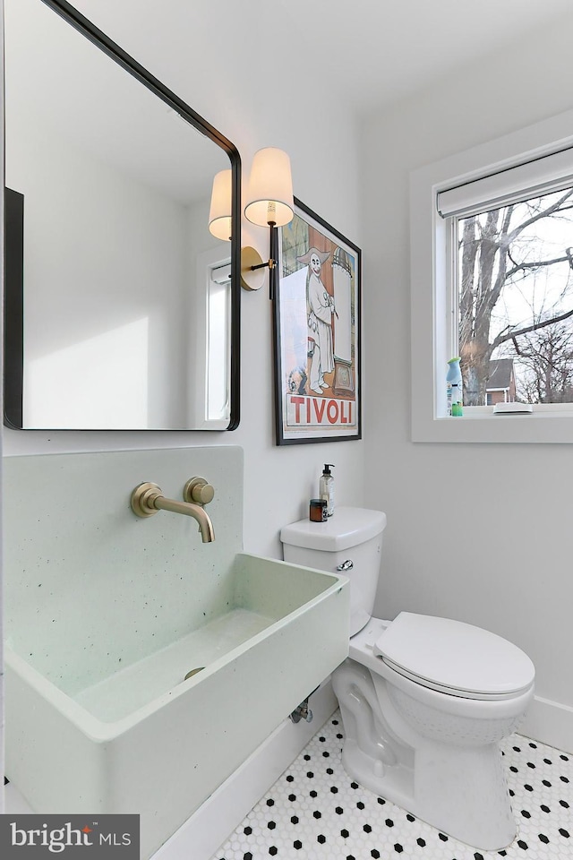 bathroom featuring tile patterned floors, toilet, and a healthy amount of sunlight