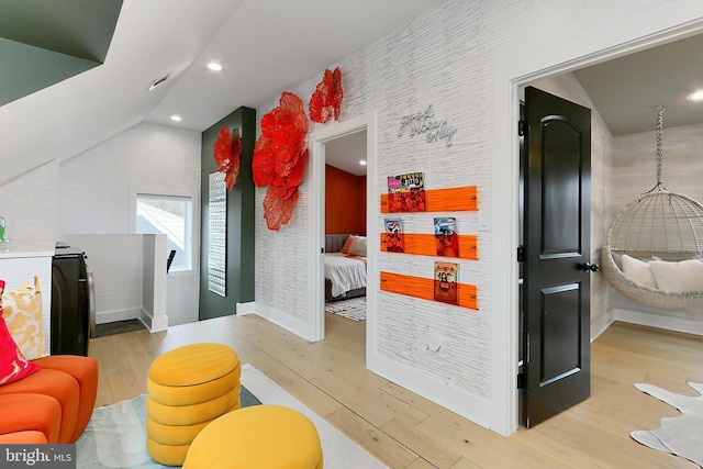 interior space featuring lofted ceiling and light hardwood / wood-style flooring