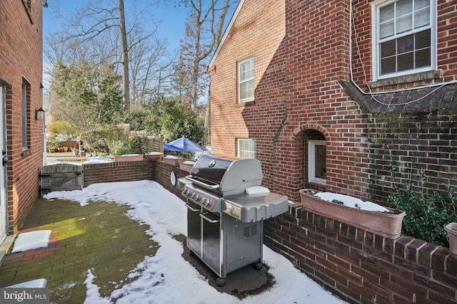 snow covered patio featuring a grill