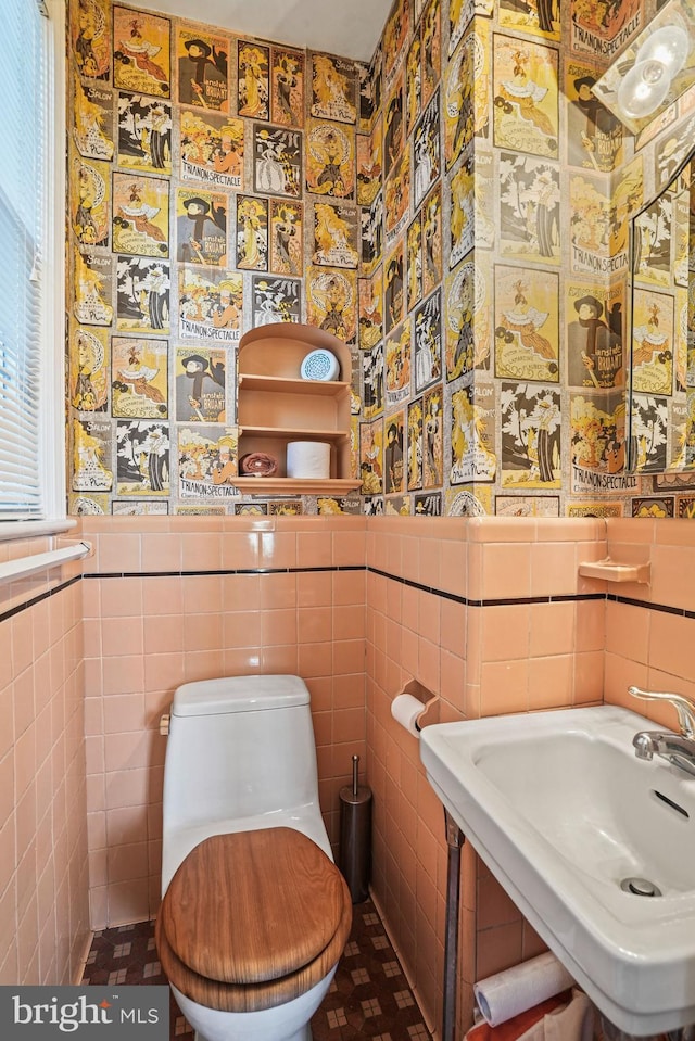 bathroom featuring tile walls, sink, and toilet