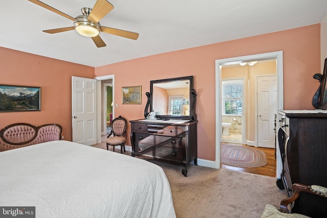 carpeted bedroom with ensuite bathroom and ceiling fan