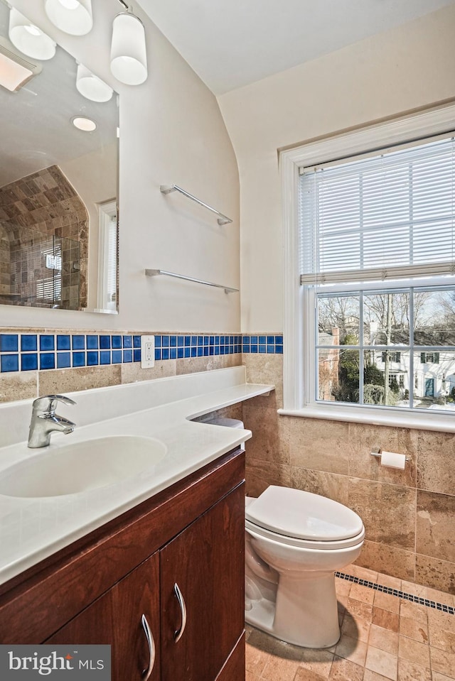 bathroom featuring tile walls, vanity, and toilet