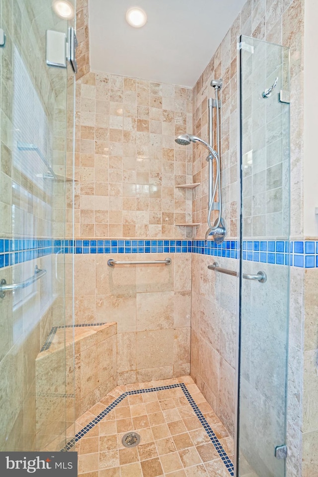 bathroom featuring a shower with door