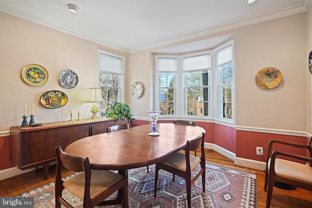 dining room featuring hardwood / wood-style floors, crown molding, and plenty of natural light