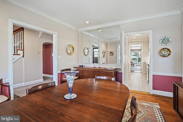 dining space featuring ornamental molding and light hardwood / wood-style floors