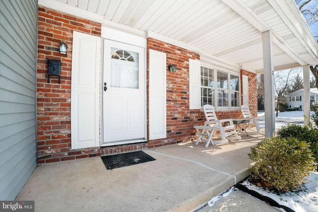 view of exterior entry featuring covered porch